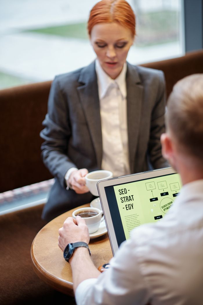 about-us-02 Professional meeting in a café with a laptop showcasing an SEO strategy. Ideal for business concepts.